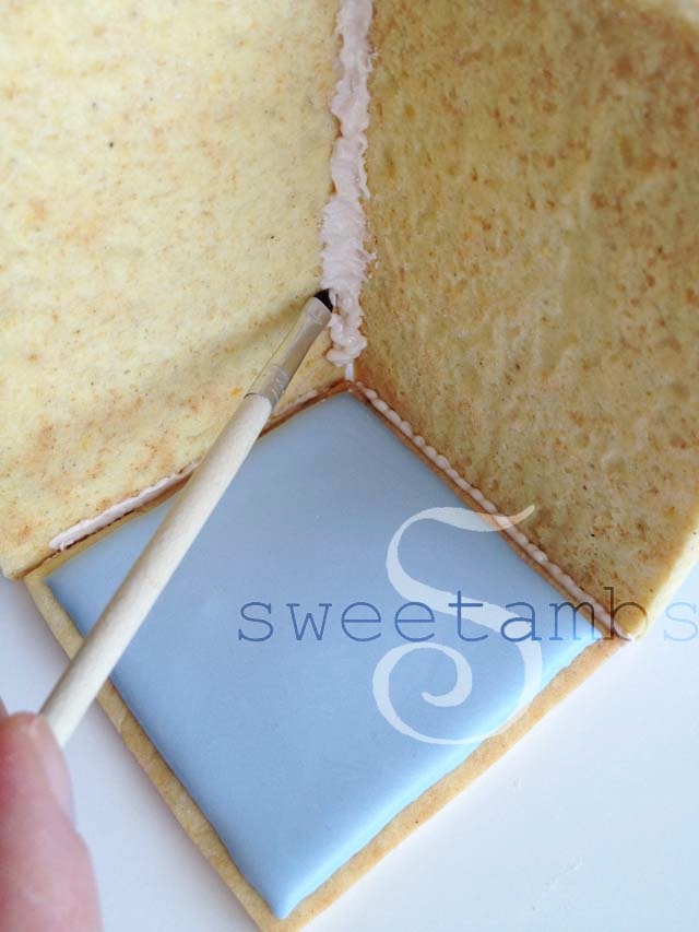 A brush pushing the icing into the seam of the two sides.