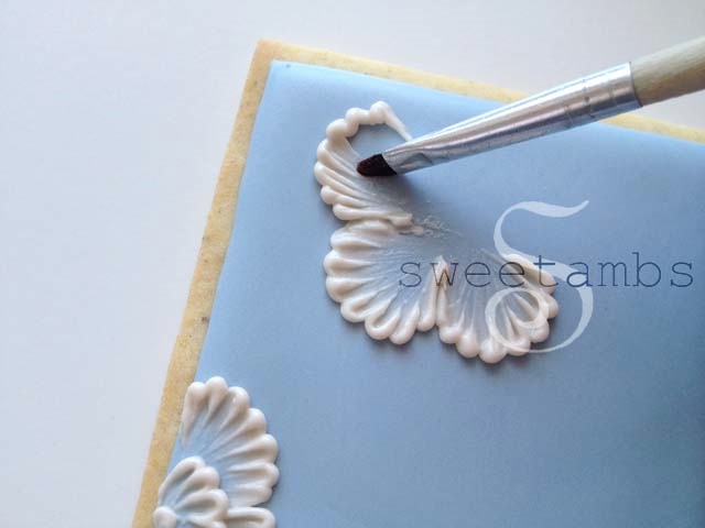 A partially completed flower being brushed to create the embroidered texture.