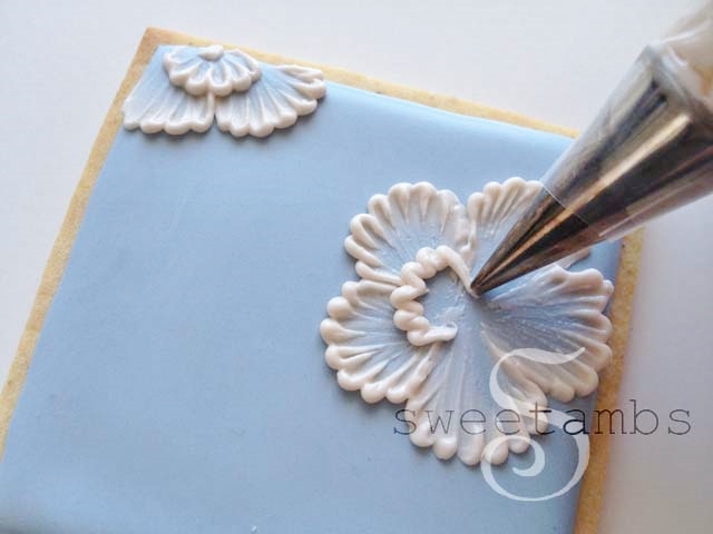 A decorating tip piping the ruffled edge of a flower petal for the second layer of petals