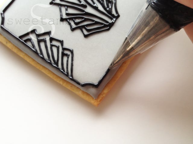 decorating tip piping black icing over the design