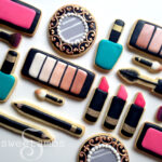 a set of cookies decorated to look like makeup, nail polish, makeup applicators, and a compact mirror