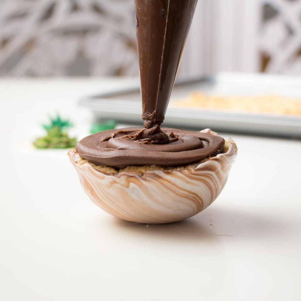 Fill the cookie cups with chocolate frosting