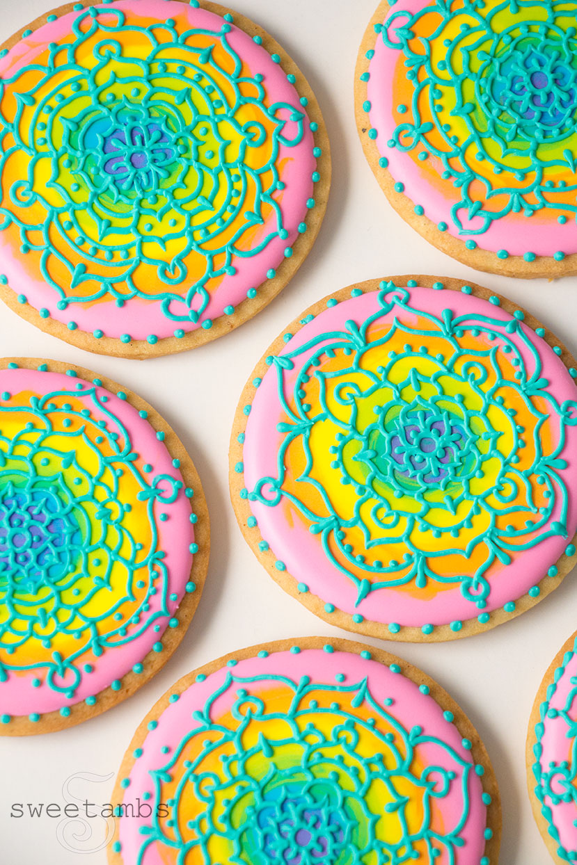 Cookies decorated with mandalas over rainbow icing