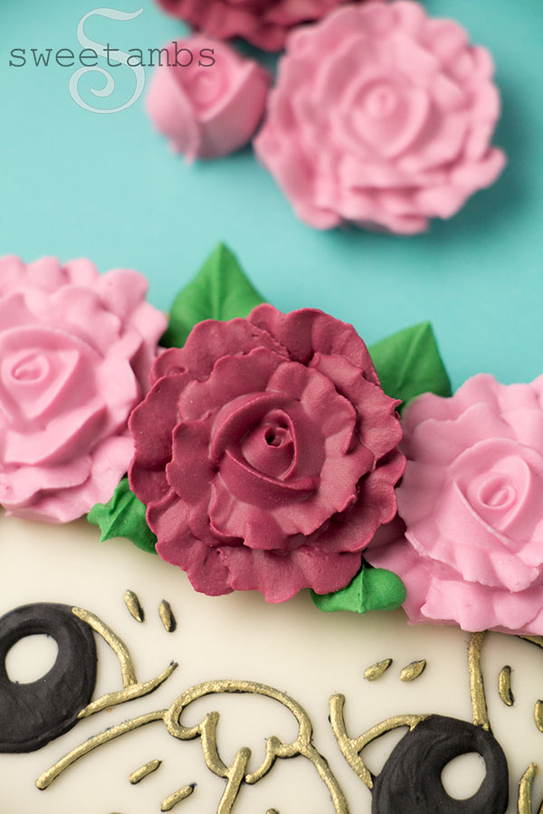 A close up of a royal icing rose on the pug cookie.
