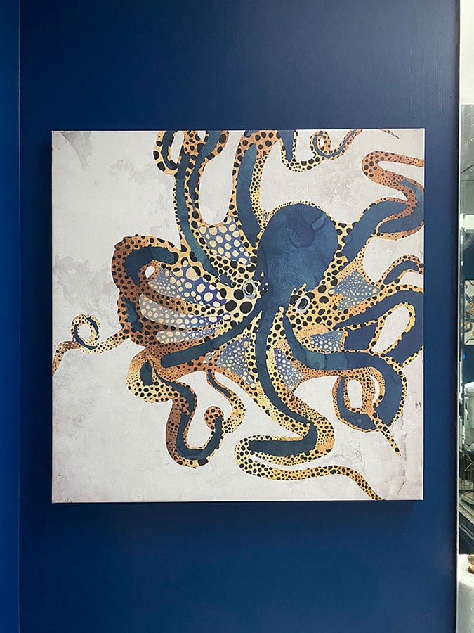 Blue and gold octopus painting on a dark blue wall