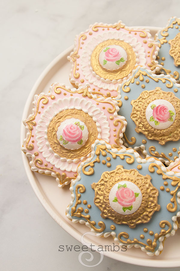 a set of cookies decorated with royal icing and fondant to look like antique brooches