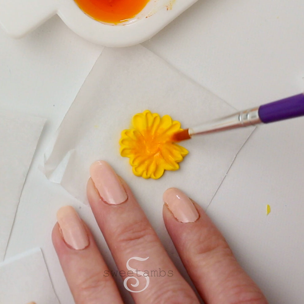 Painting the royal icing flowers with edible paint
