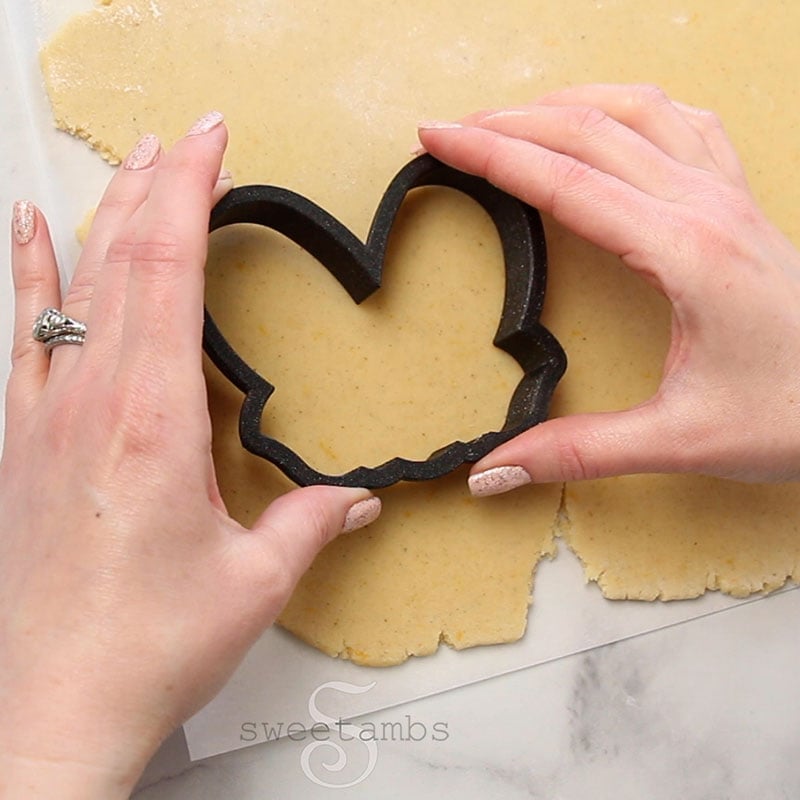 Hands pressing a cookie cutter into the dough