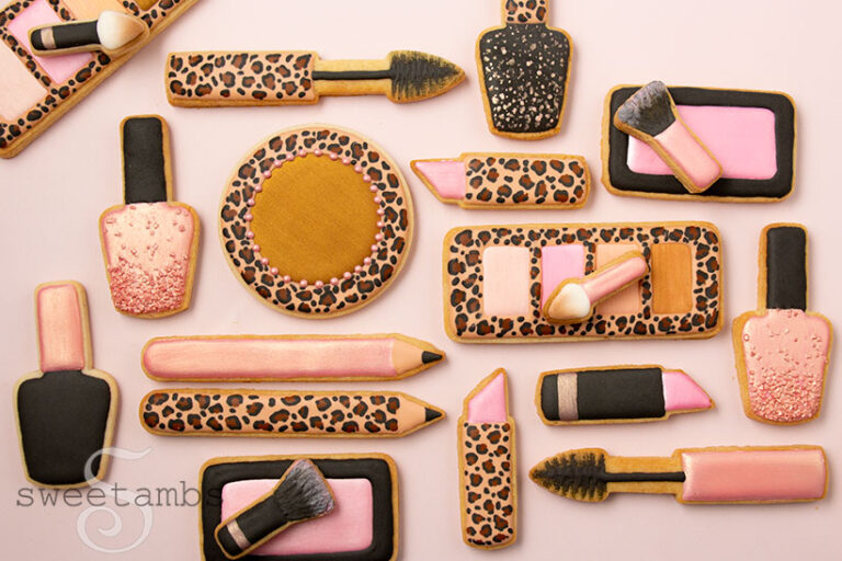 A set of makeup cookies decorated with leopard print, black, pink, and rose gold royal icing