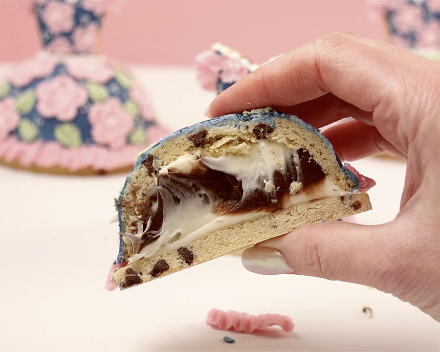 A cross section of one of the dress cookies showing layers of vanilla and chocolate frosting inside