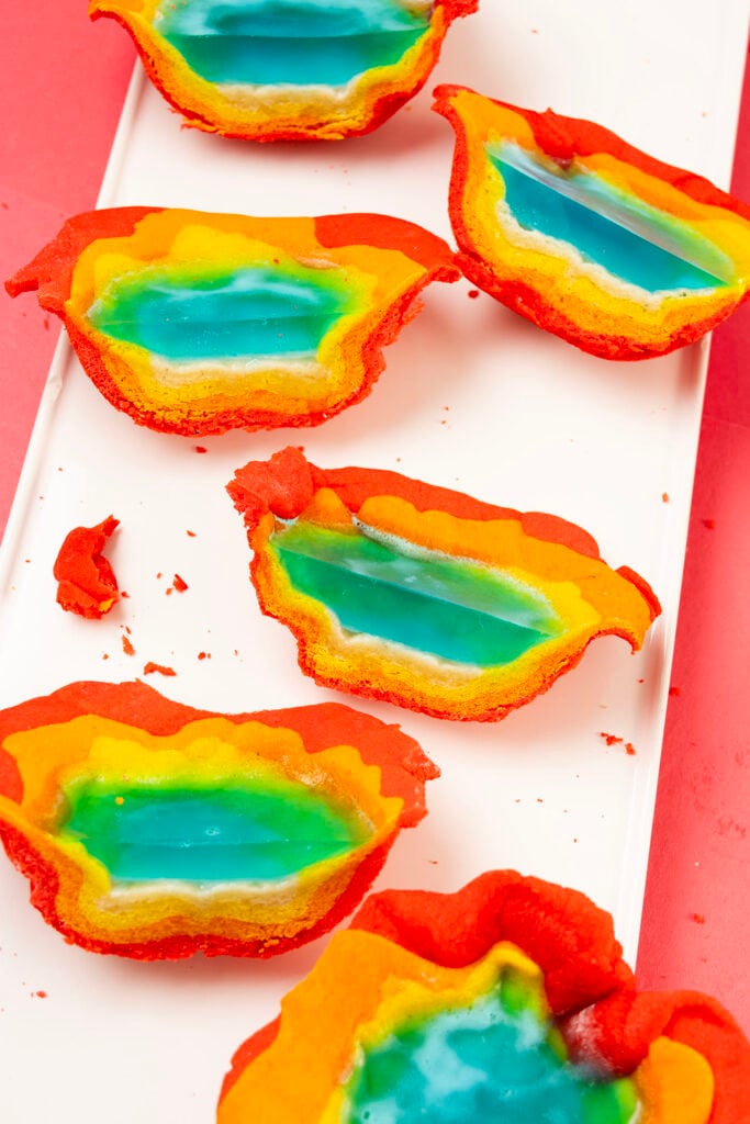 Sliced rainbow cookies revealing a cross section of layered rainbow cookie dough with blue gelatin in the center