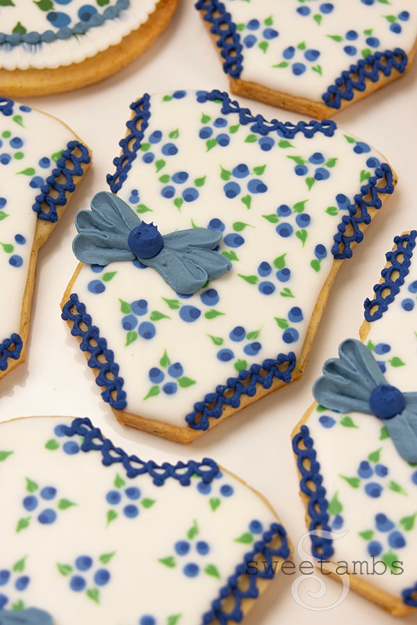 Cookies decorated to look like baby rompers with a blueberry pattern.