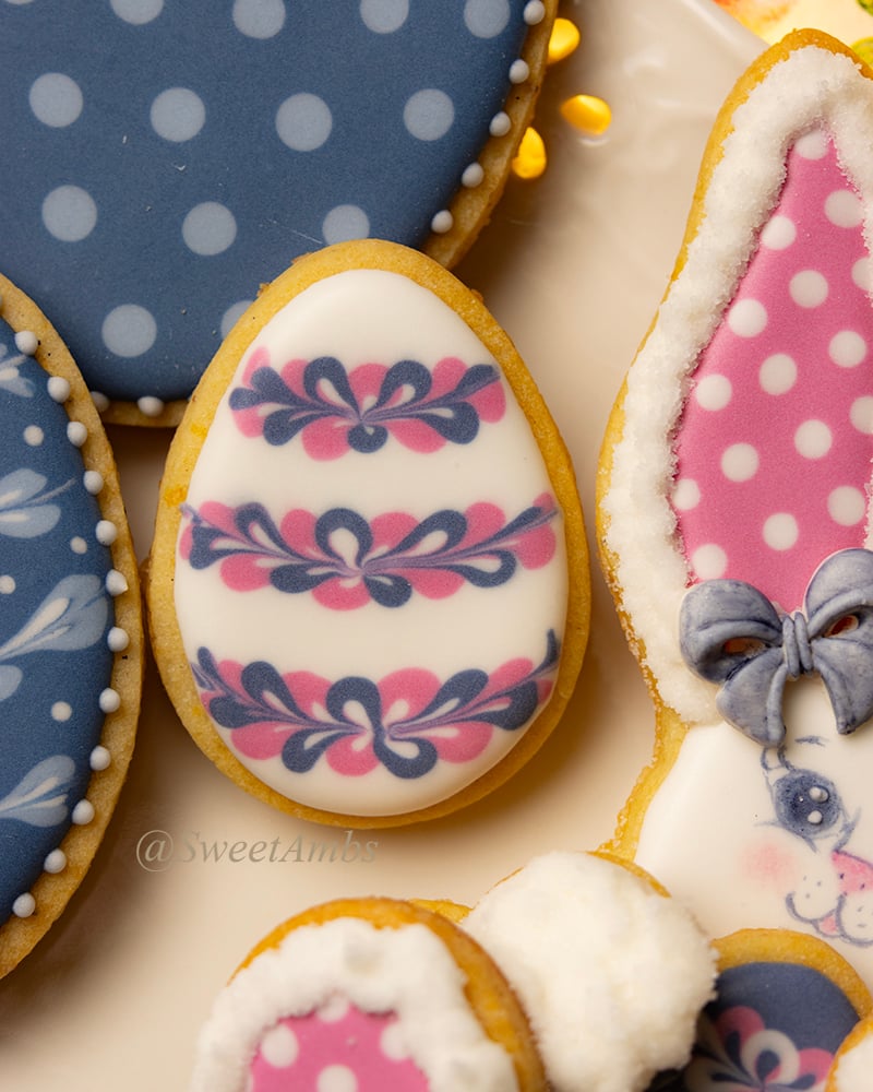 A decorated Easter egg cookie surrounded by other Easter decorated cookies on a platter.