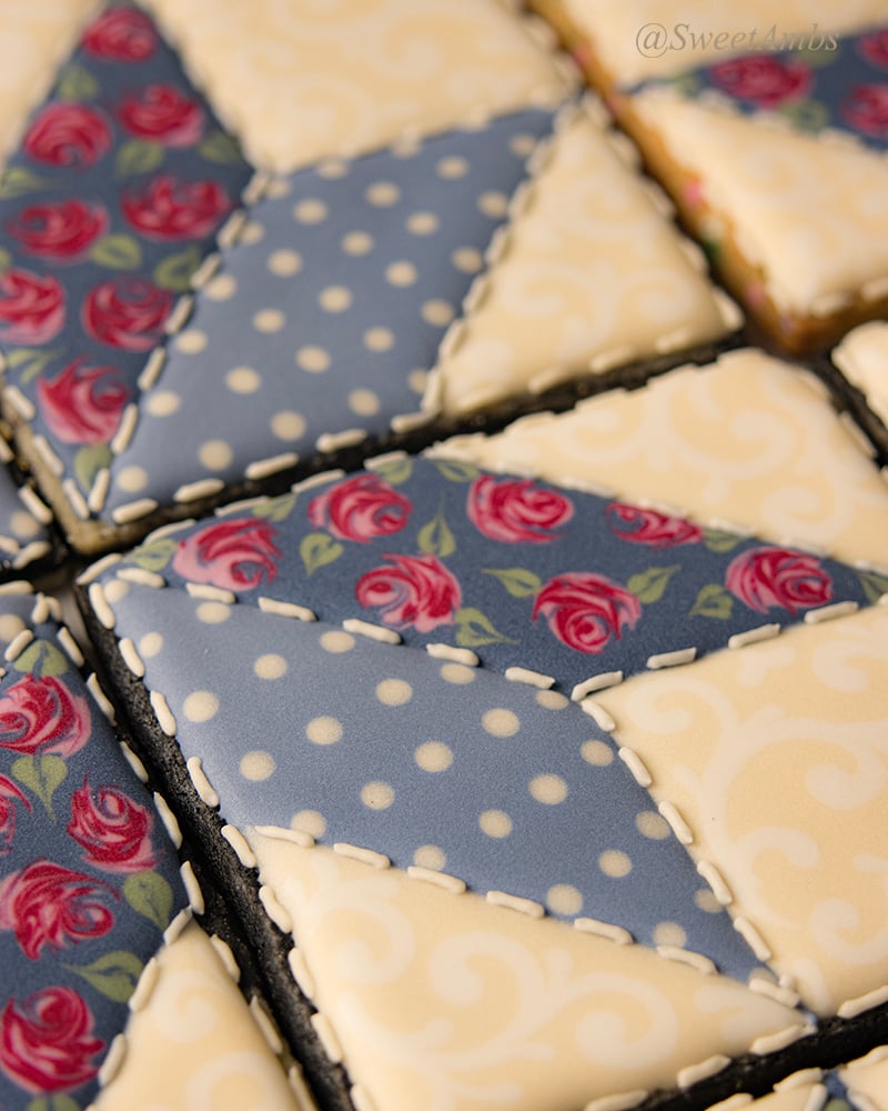 A close up of the star quilt cookies decorated with royal icing, showing the stitching detail around the patches.